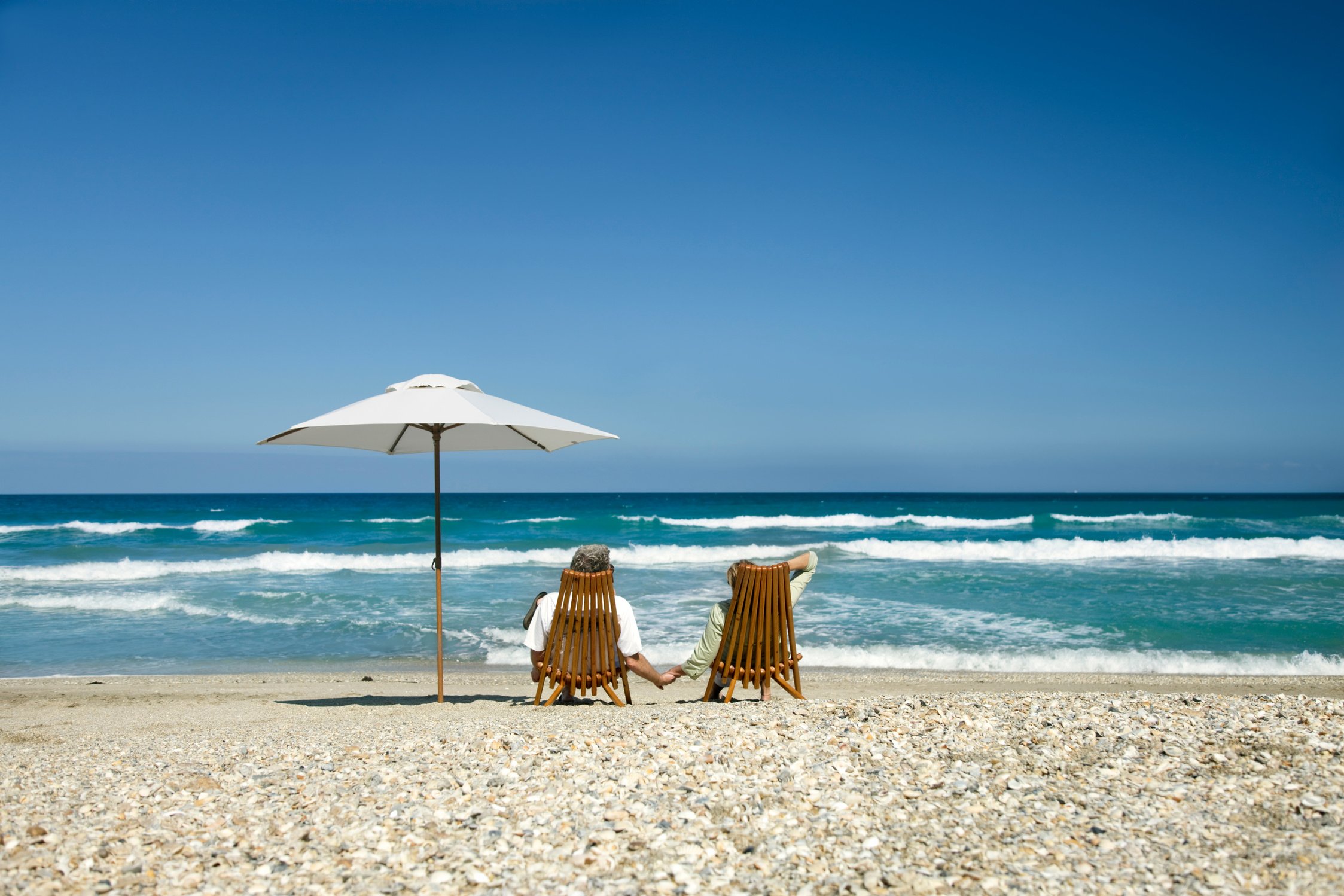 retired couple relaxing on beach